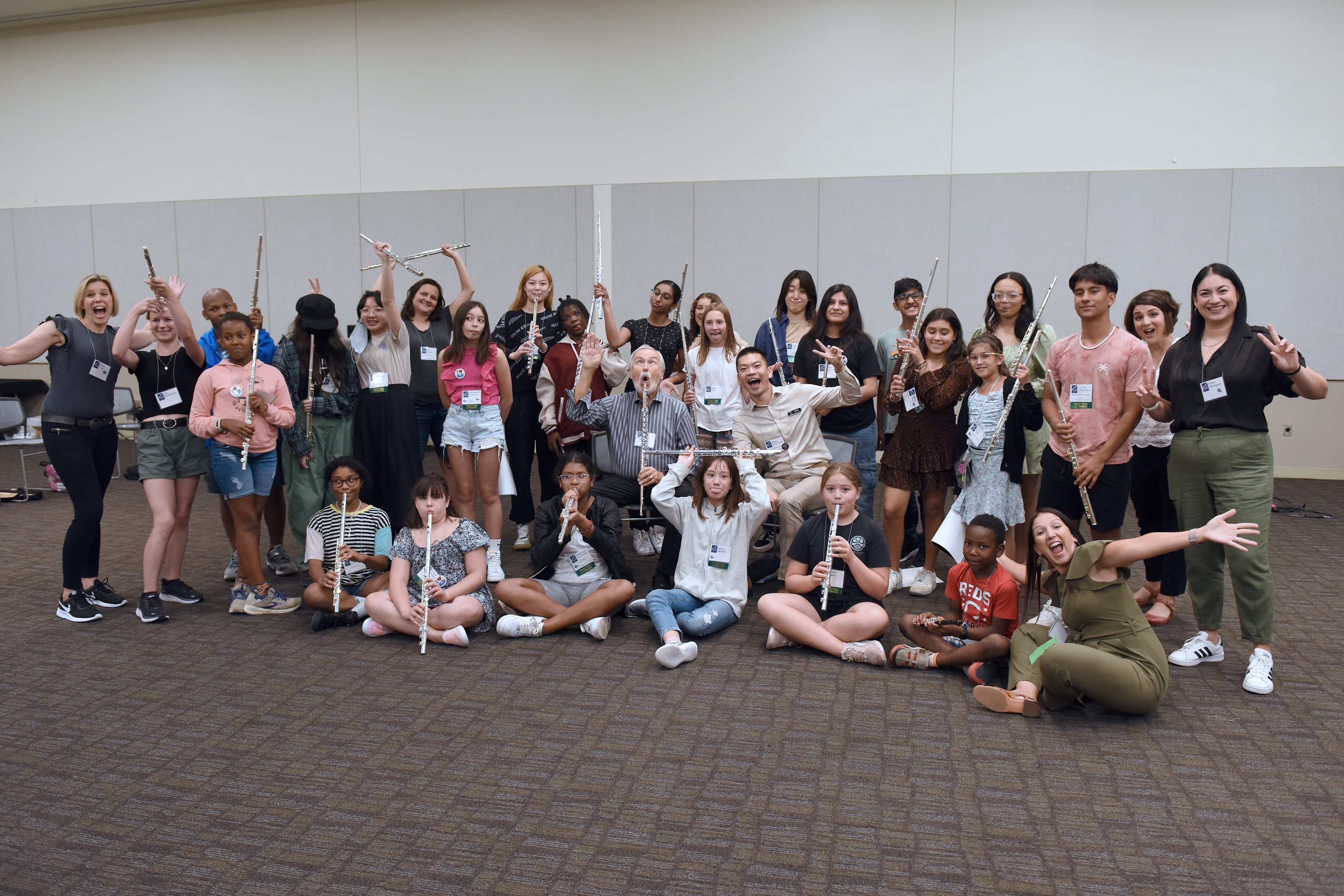 a group of young flute students pose for a silly picture