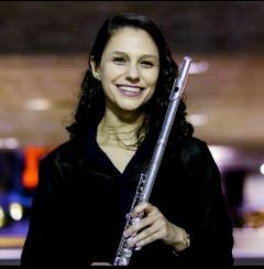 A person smiling and holding a flute